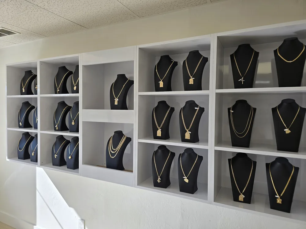 Wall of gold chains on black velvet busts inside Nicole Jewelry
